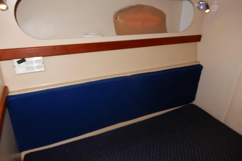Slide: The Image of 1999 Cruisers Yachts 3075 Rogue interior cabin with blue upholstery and wooden accents. - 37
