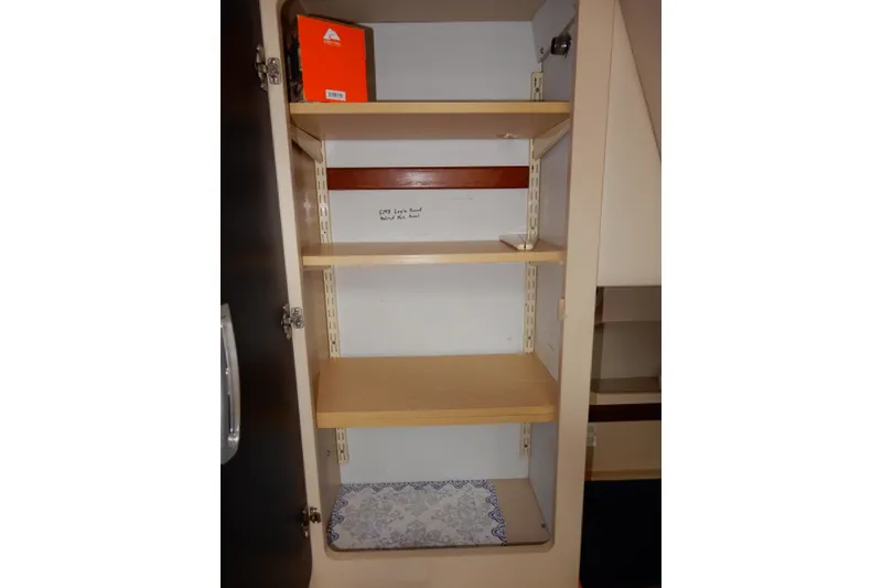 Slide: The Image of Empty wooden shelves inside a 1999 Cruisers Yachts 3075 Rogue cabinet. - 41