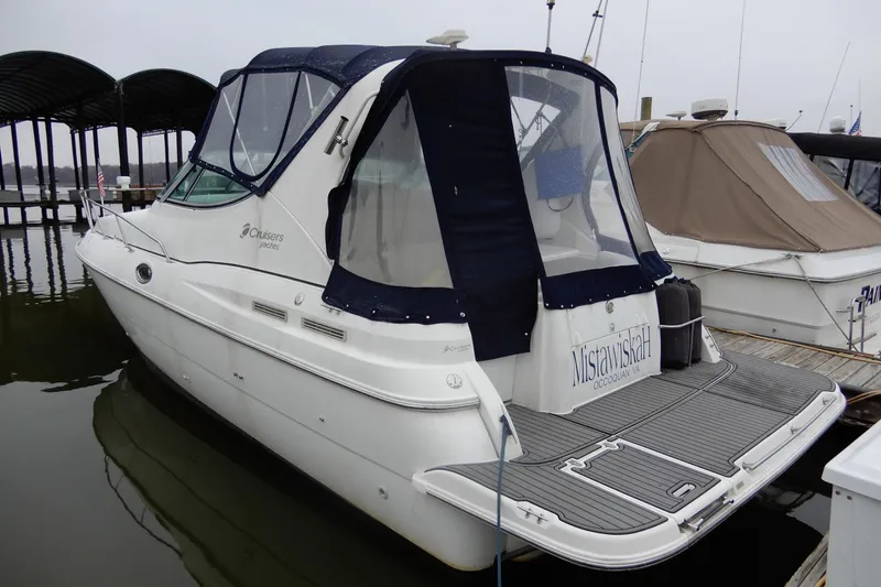 Slide: The Image of 1999 Cruisers Yachts 3075 Rogue docked, featuring a covered cockpit and sleek design. - 5