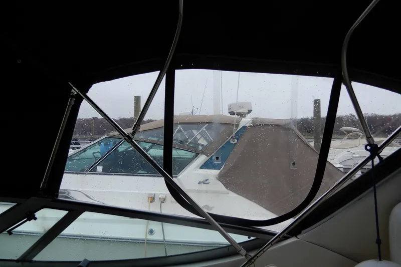 Slide: The Image of 1999 Cruisers Yachts 3075 Rogue docked, viewed through a rain-speckled window. - 21