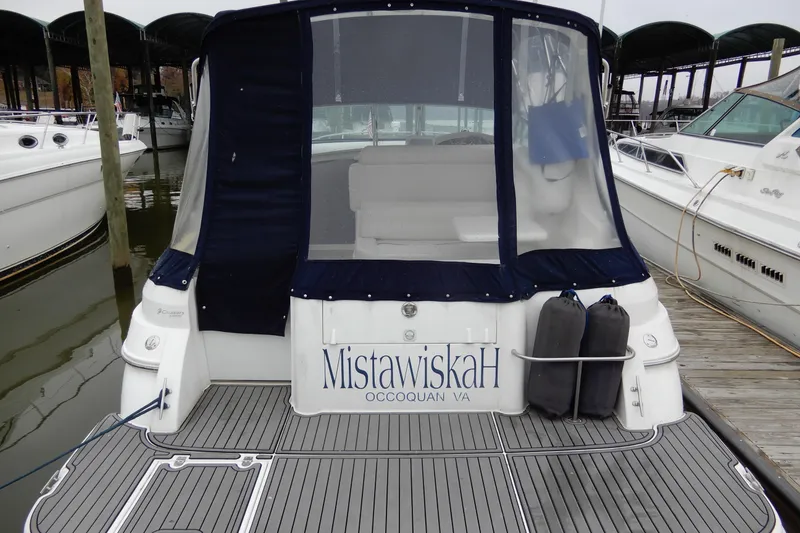 Slide: The Image of 1999 Cruisers Yachts 3075 Rogue docked, featuring rear view with protective cover. - 6