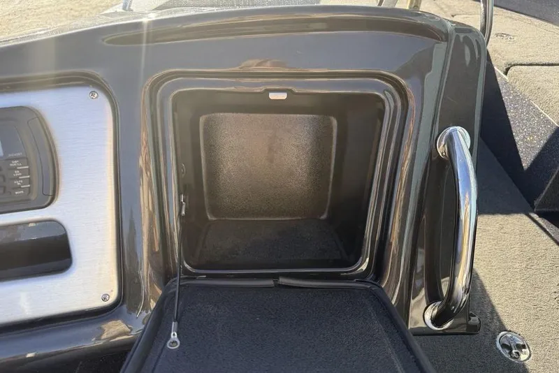 Slide: The Image of Open storage compartment on a 2014 Stratos 386 XF boat, featuring a sleek black finish. - 23
