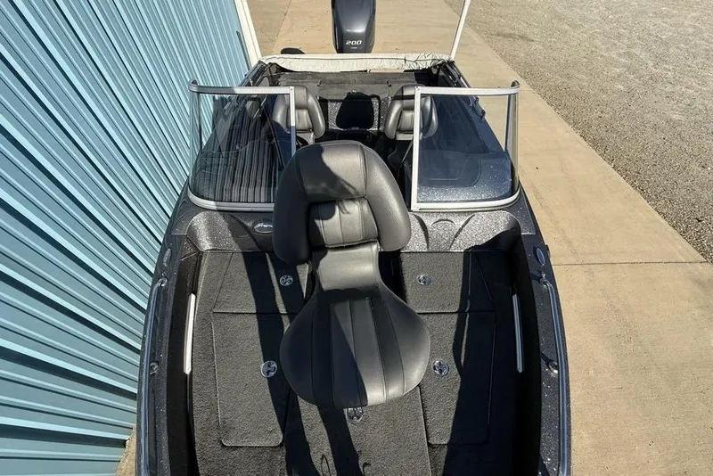 Slide: The Image of 2014 Stratos 386 XF boat interior with seating and windshield, parked near a blue wall. - 28