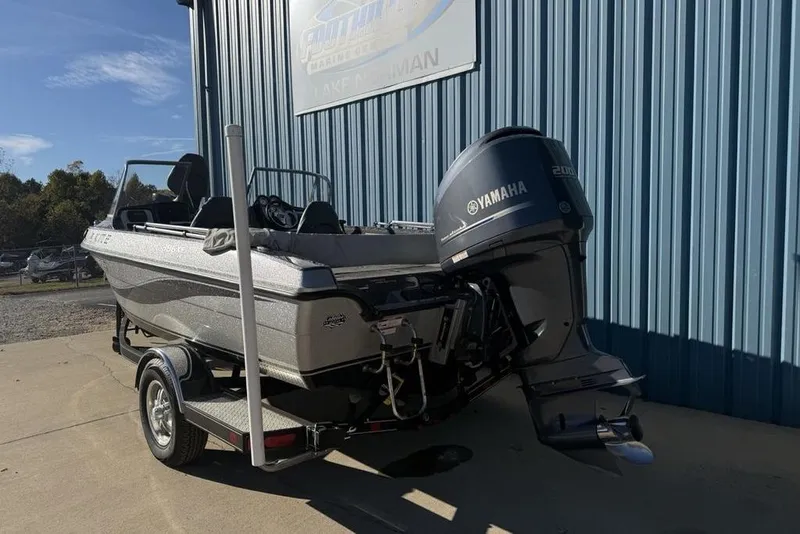 Slide: The Image of 2014 Stratos 386 XF boat with Yamaha engine, parked outside a blue building. - 3