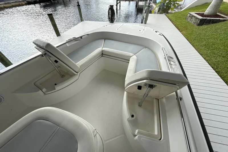 Slide: The Image of 2015 Boston Whaler 270 Dauntless boat interior with cushioned seating and storage compartments. - 14