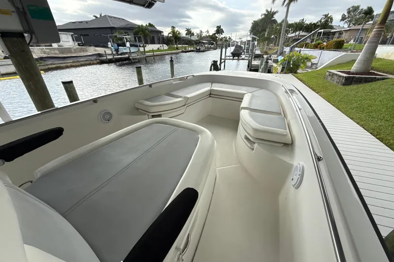 Slide: The Image of 2015 Boston Whaler 270 Dauntless boat interior with seating, docked by a canal. - 17