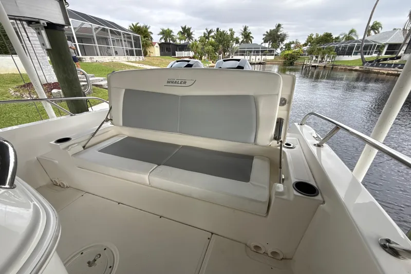 Slide: The Image of 2015 Boston Whaler 270 Dauntless boat interior with cushioned seating by the water. - 24
