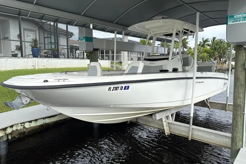 Slide: The Image of 2015 Boston Whaler 270 Dauntless boat docked under a canopy. - 29