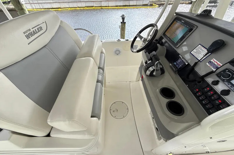 Slide: The Image of 2015 Boston Whaler 270 Dauntless helm with steering wheel, controls, and navigation display. - 4