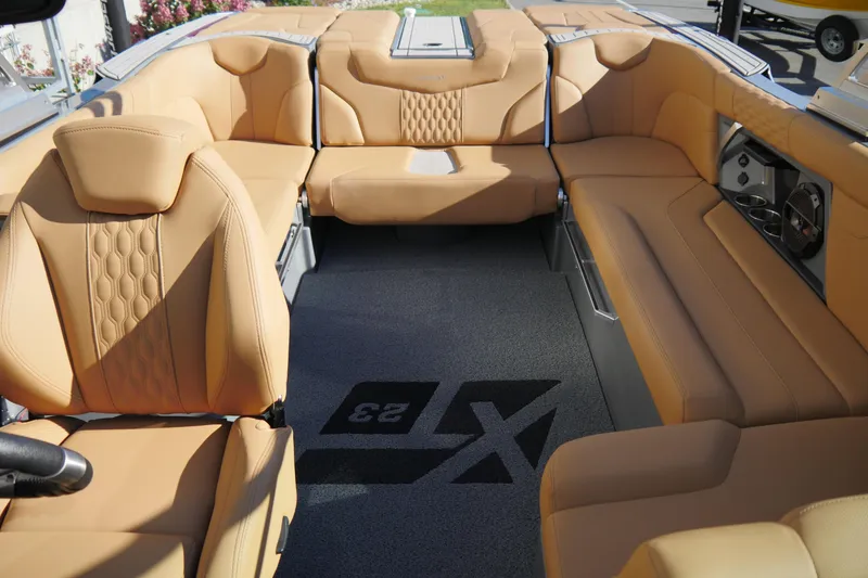 Slide: The Image of 2022 MasterCraft XT23 boat interior with tan leather seating and modern design. - 12