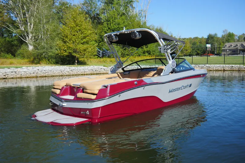 Slide: The Image of 2022 MasterCraft XT23 boat on calm water, featuring sleek design and vibrant red color. - 3