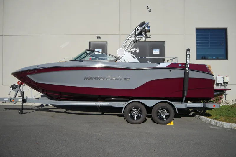 Slide: The Image of 2022 MasterCraft XT23 boat on trailer, parked outdoors, side view. - 5