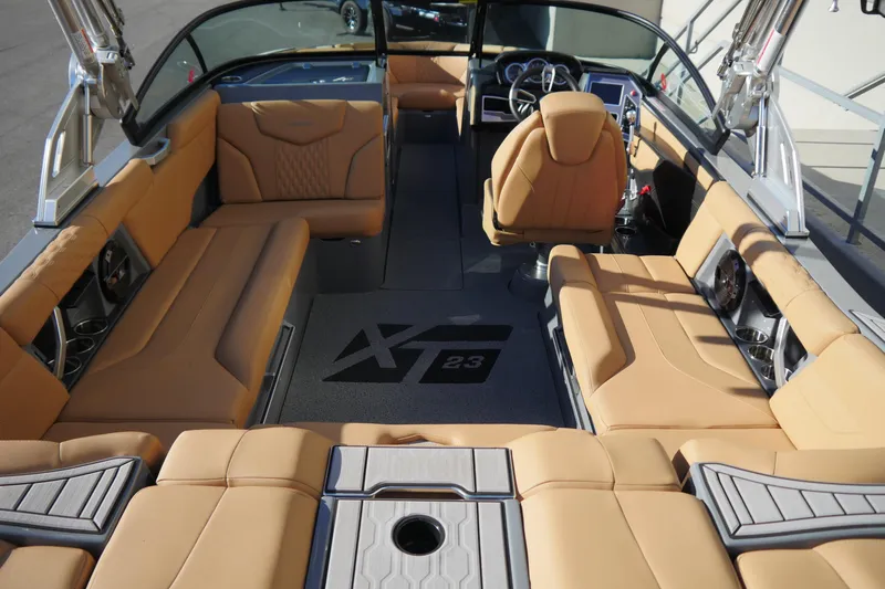 Slide: The Image of Interior of 2022 MasterCraft XT23 boat with tan seating and modern dashboard. - 7