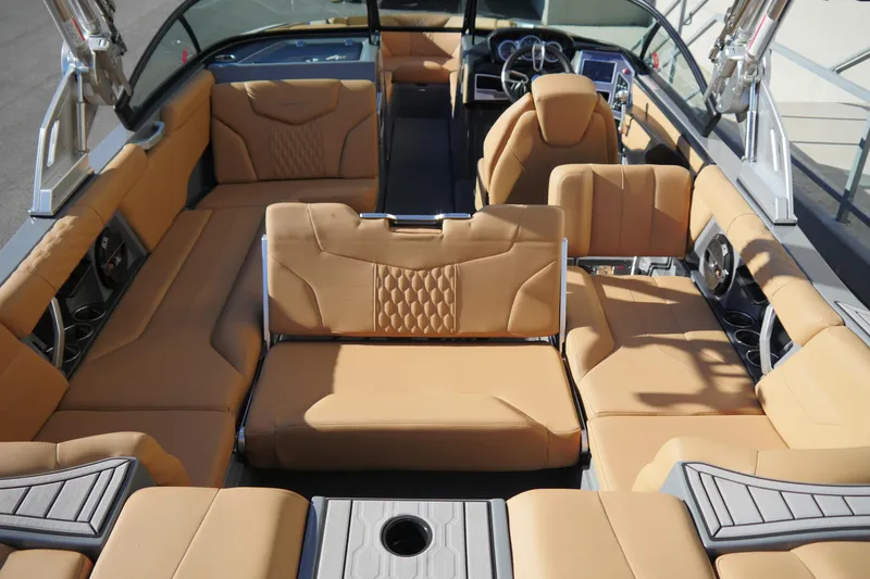 Slide: The Image of 2022 MasterCraft XT23 boat interior with tan seating and modern dashboard design. - 8
