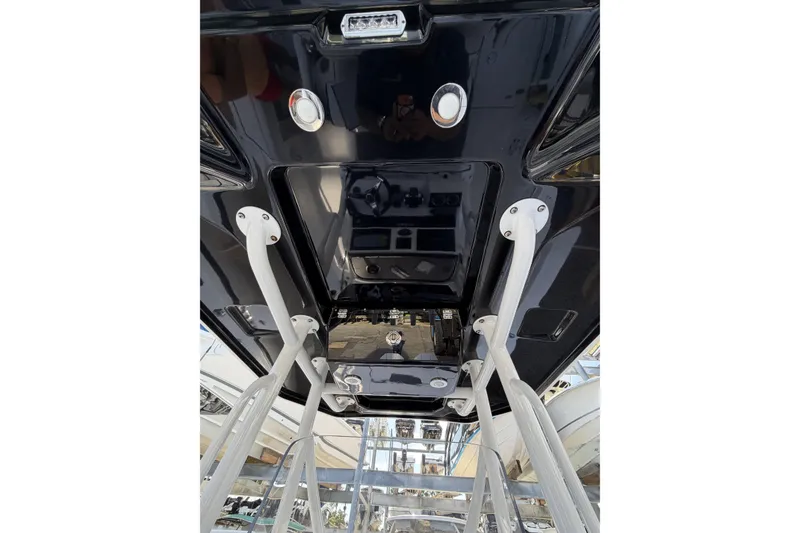 Slide: The Image of 2021 Blackfin 252 CC boat's underside view with sleek black finish and sturdy supports. - 11