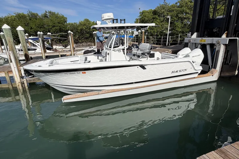 Slide: The Image of 2021 Blackfin 252 CC boat on a lift, with clear blue sky background. - 2
