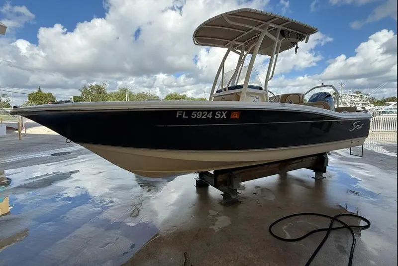 Slide: The Image of 2017 Scout 195 Sportfish boat on a stand, under a cloudy sky. - 0