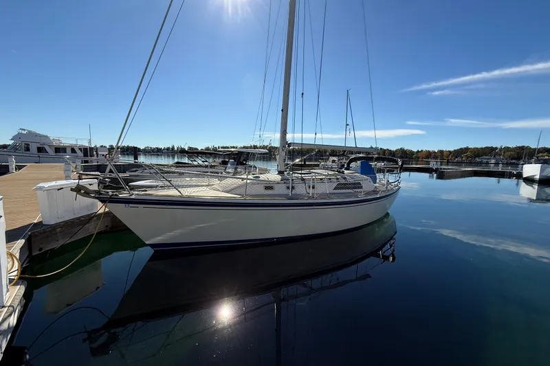Slide: The Image of 1983 O'Day 34 sailboat docked in a serene marina under clear blue skies. - 2