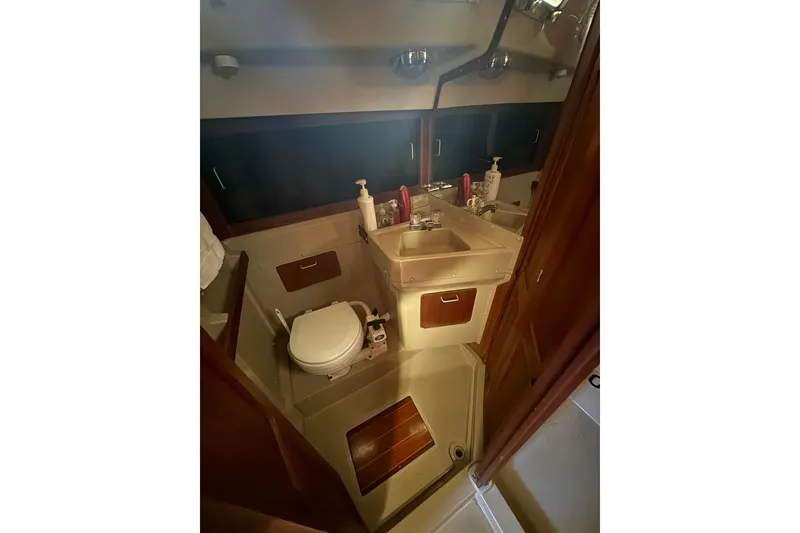 Slide: The Image of 1983 O'Day 34 sailboat bathroom with sink, toilet, and storage cabinets. - 27