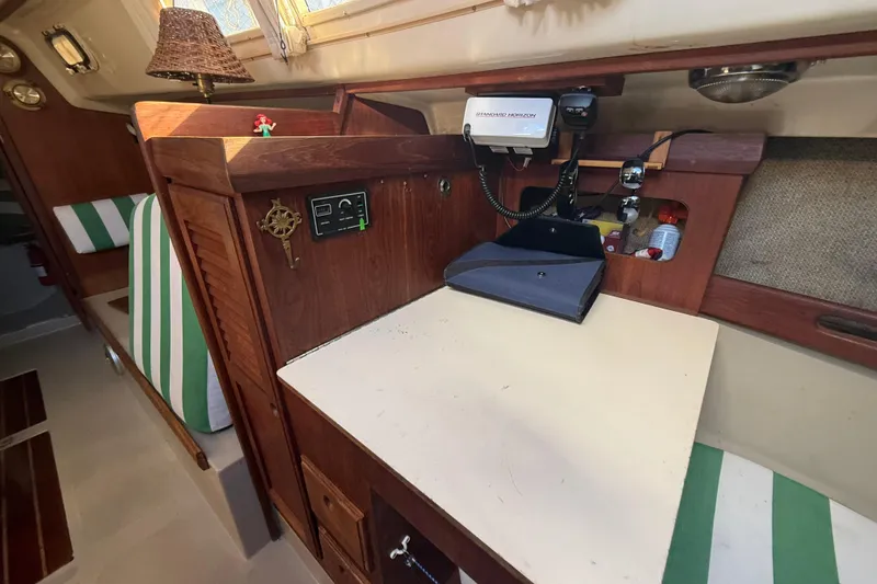Slide: The Image of Interior of 1983 O'Day 34 sailboat with striped seating, wall art, and a Newport heater. - 28