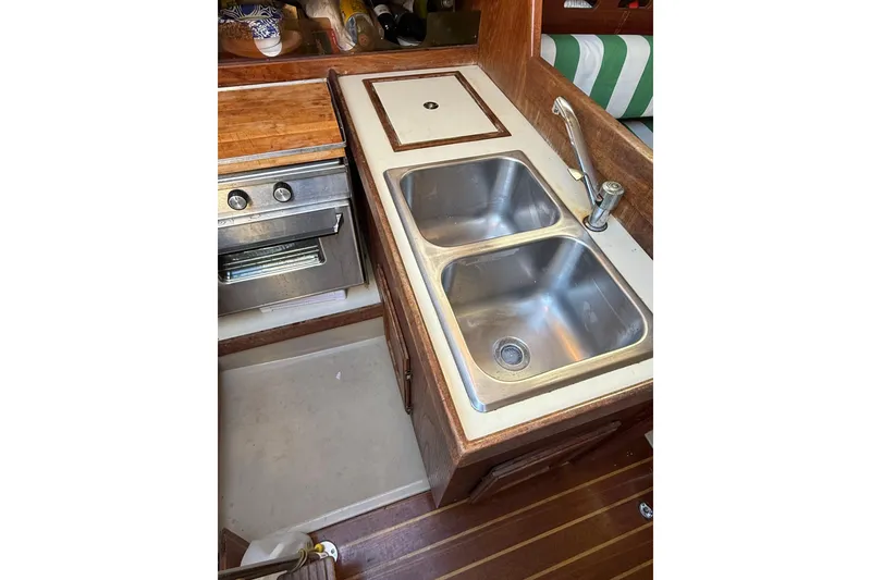 Slide: The Image of Green and white striped seating inside a 1983 O'Day 34 sailboat cabin. - 30