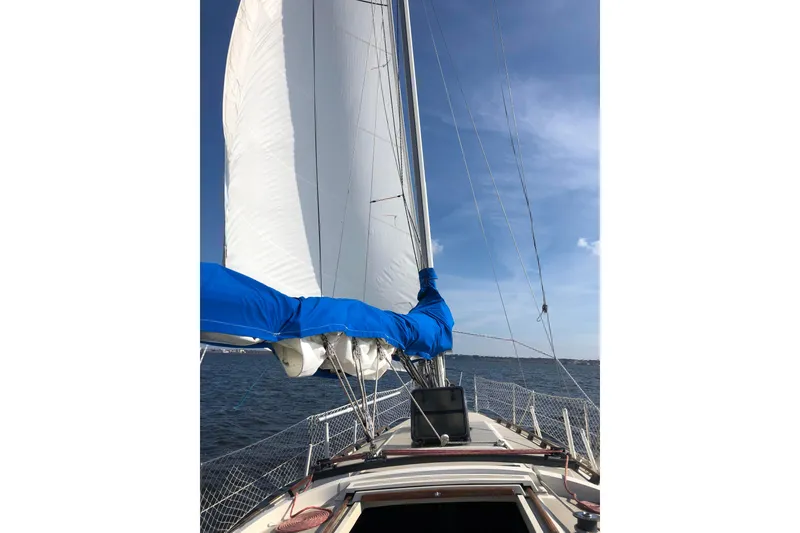 Slide: The Image of 1983 O'Day 34 sailboat with sails up on a sunny day at sea. - 35