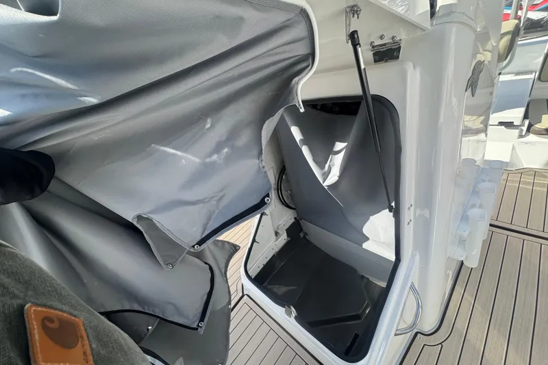 Slide: The Image of Yamaha Boats 2026 222 FSH Sport E interior storage compartment with gray cover. - 16