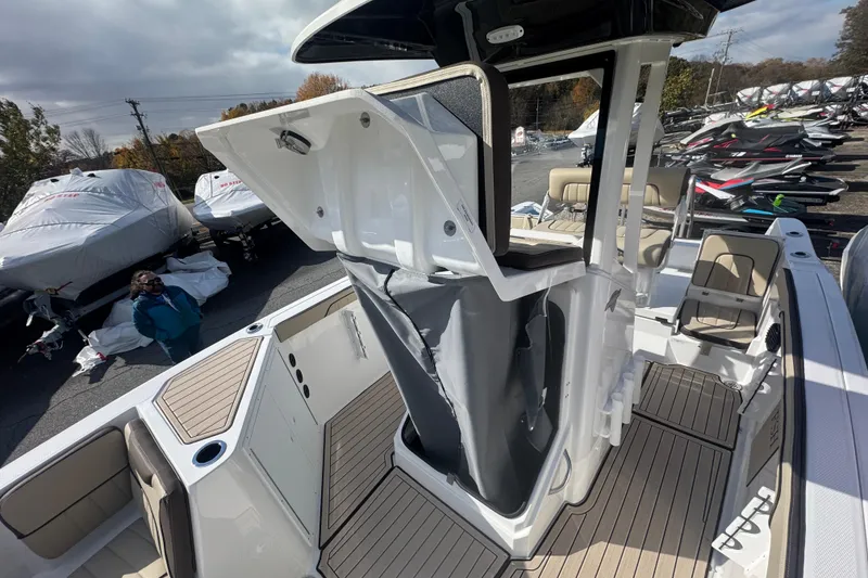Slide: The Image of 2026 Yamaha Boats 222 FSH Sport E interior with seating and storage, displayed outdoors. - 18