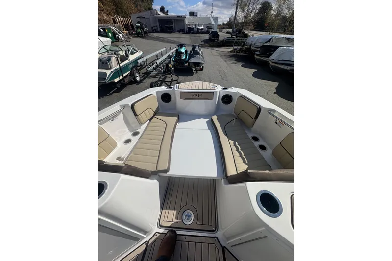 Slide: The Image of 2026 Yamaha Boats 222 FSH Sport E interior with beige seating and cup holders. - 19