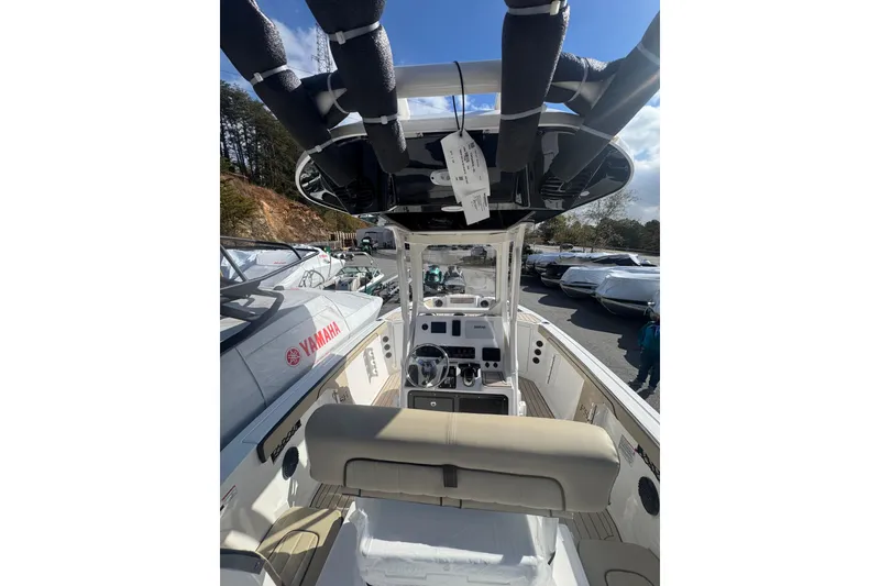 Slide: The Image of 2026 Yamaha Boats 222 FSH Sport E interior with console and seating, displayed outdoors. - 20