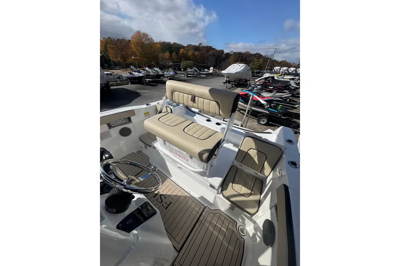 Slide: The Image of 2026 Yamaha Boats 222 FSH Sport E interior with beige seating and steering wheel. - 23