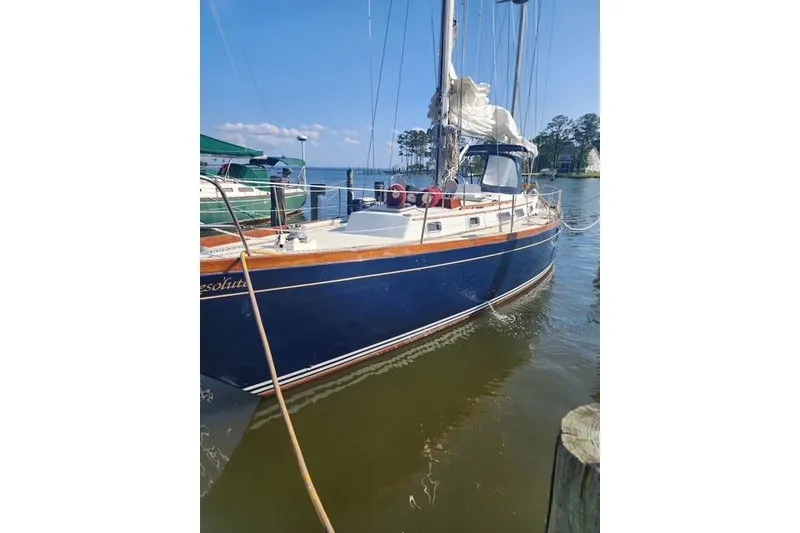 Slide: The Image of 1984 Bristol 45.5 Center Cockpit sailboat docked in a serene marina setting. - 1