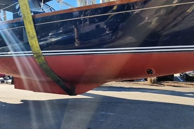 Slide: The Image of 1984 Bristol 45.5 Center Cockpit sailboat hull in dry dock, showing red and blue paint. - 10