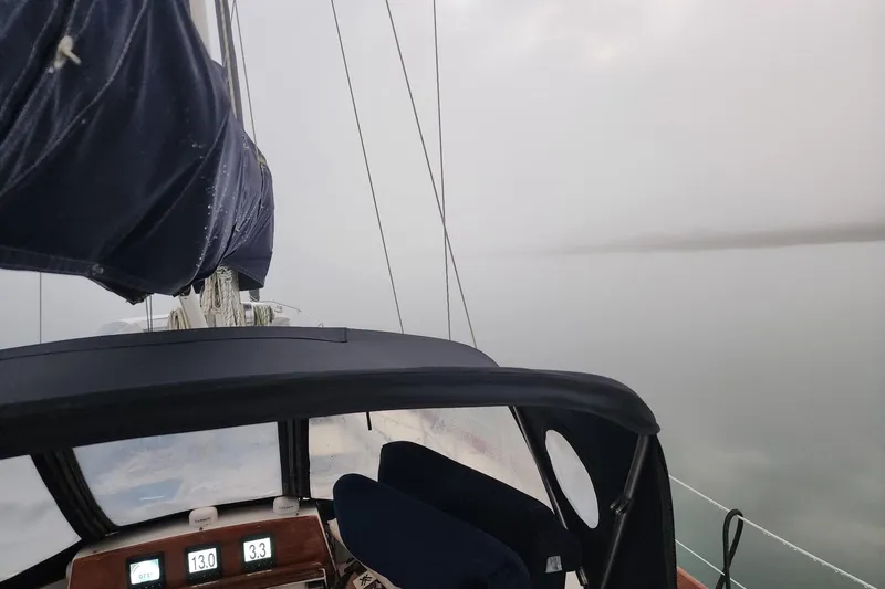 Slide: The Image of 1984 Bristol 45.5 Center Cockpit sailboat navigating in foggy waters. - 19