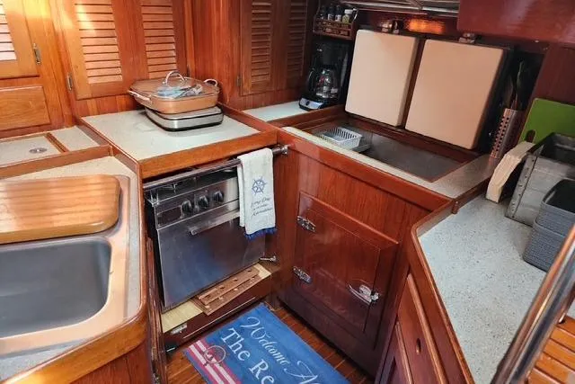 Slide: The Image of 1984 Bristol 45.5 Center Cockpit yacht kitchen with wooden cabinetry and modern appliances. - 25