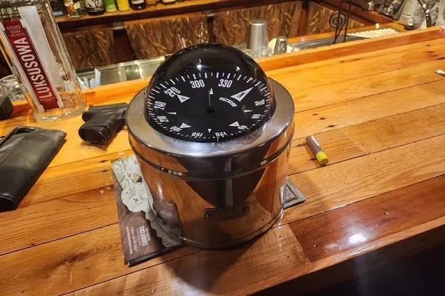 Slide: The Image of Large nautical compass on a wooden bar counter, Bristol 45.5 Center Cockpit, 1984. - 36