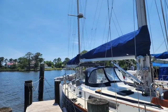 Slide: The Image of 1984 Bristol 45.5 Center Cockpit sailboat docked by a serene waterfront. - 4