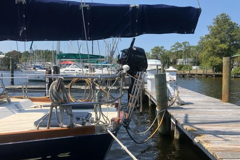 Slide: The Image of 1984 Bristol 45.5 Center Cockpit sailboat docked at a marina with outboard motor. - 7