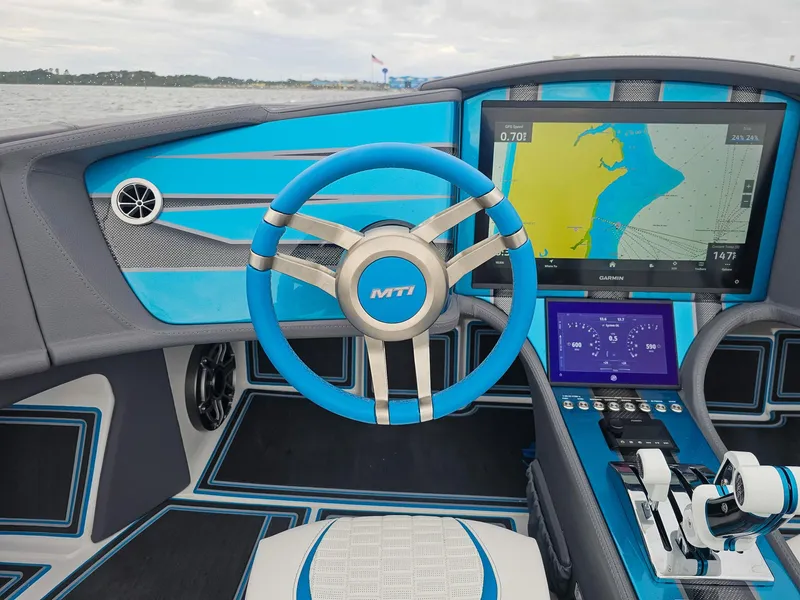 Slide: The Image of Interior of 2026 MTI 440X boat with blue steering wheel and navigation display. - 21