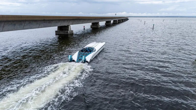 Slide: The Image of A 2026 MTI 440X powerboat cruising near a long bridge over open water. - 50