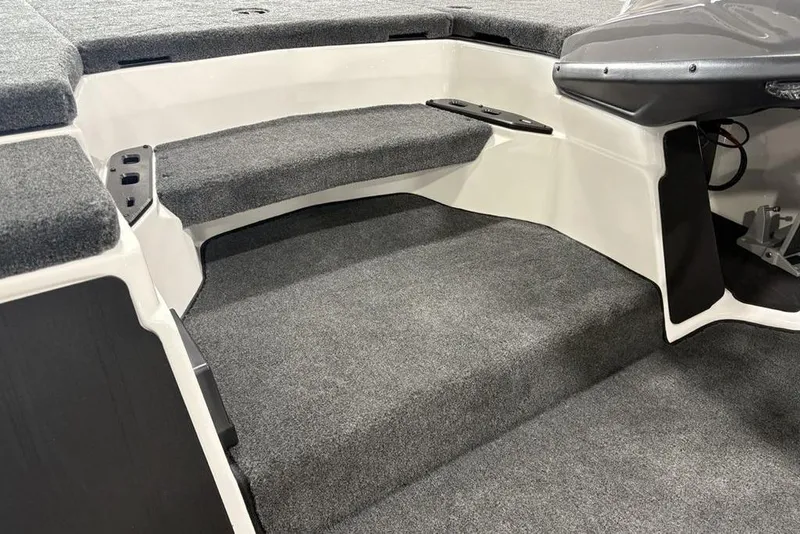 Slide: The Image of 2025 Skeeter ZXR20 boat interior with gray carpeted seating and storage area. - 11