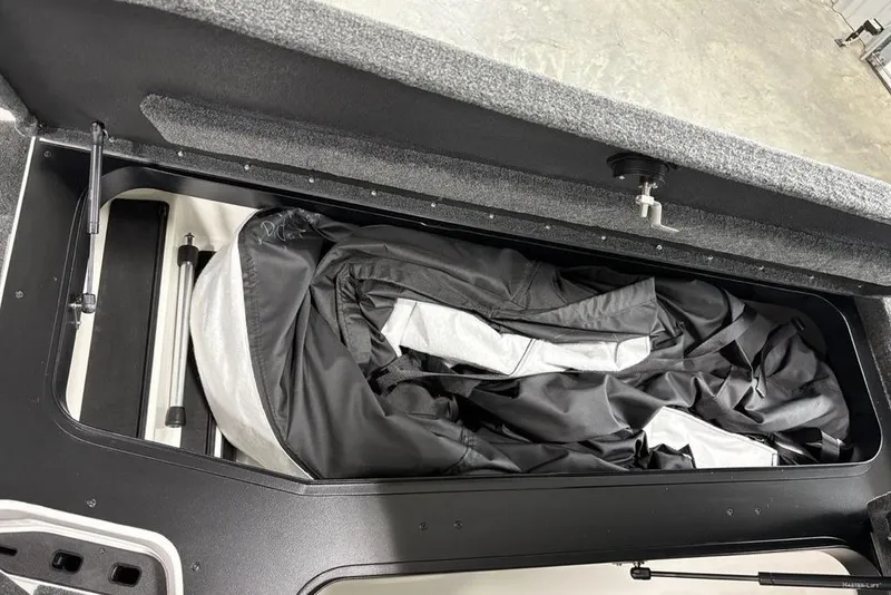 Slide: The Image of 2025 Skeeter ZXR20 storage compartment with neatly folded cover inside. - 13
