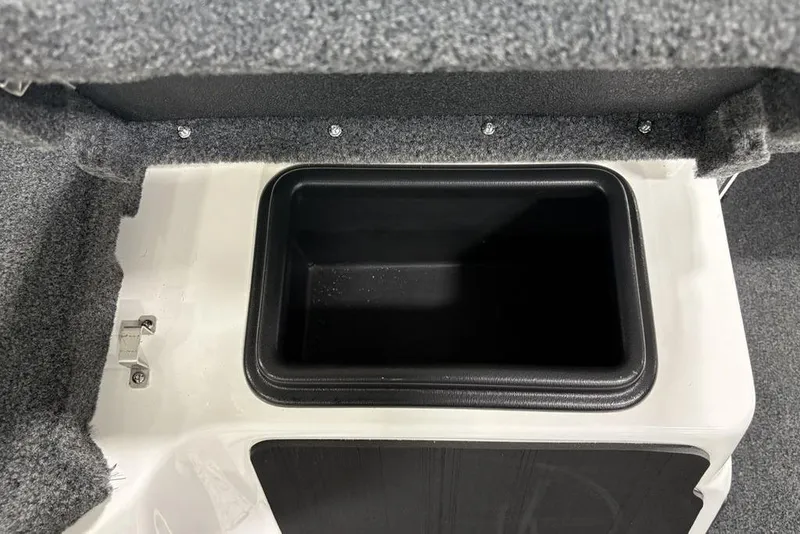 Slide: The Image of Storage compartment in 2025 Skeeter ZXR20 boat, featuring a black interior and carpeted edges. - 16