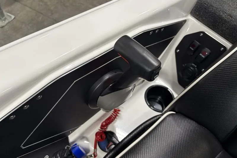 Slide: The Image of 2025 Skeeter ZXR20 boat control panel with throttle lever and cup holder. - 24