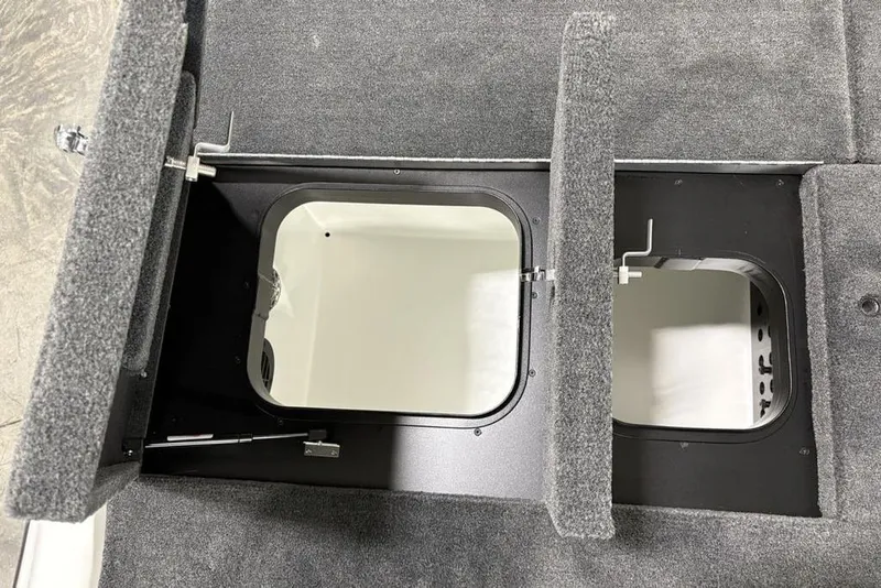 Slide: The Image of Storage compartments in a 2025 Skeeter ZXR20 boat, featuring carpeted lids and secure latches. - 28
