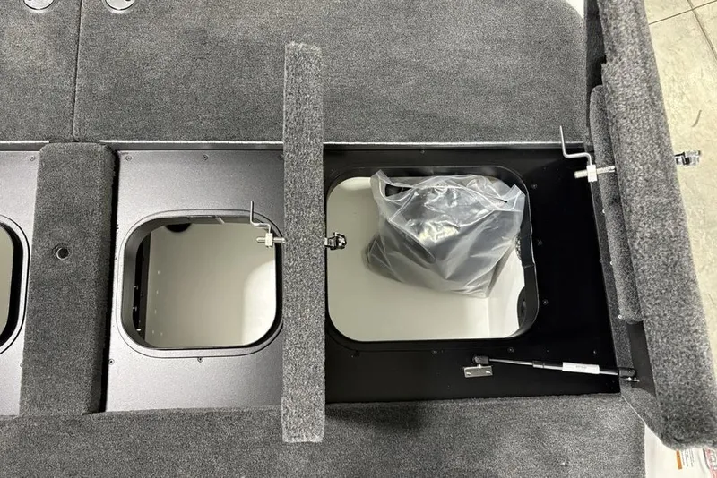 Slide: The Image of 2025 Skeeter ZXR20 boat storage compartments with carpeted lids and interior bag. - 29