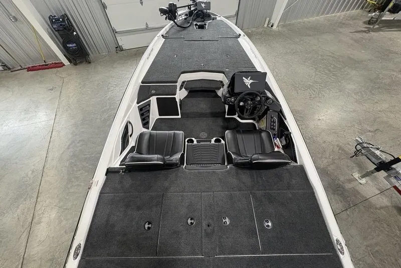 Slide: The Image of 2025 Skeeter ZXR20 boat interior with black seats and spacious deck in a garage setting. - 31