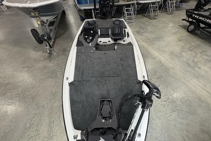 Slide: The Image of 2025 Skeeter ZXR20 boat interior with gray carpet and dual seats in showroom. - 33