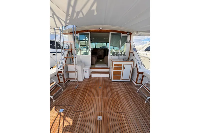 Slide: The Image of 1987 Bertram 46.6 yacht interior with wooden deck and seating area. - 10