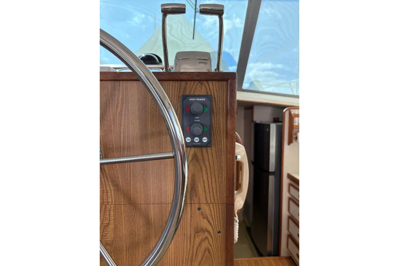 Slide: The Image of 1987 Bertram 46.6 yacht helm with wooden panel and steering wheel. - 11
